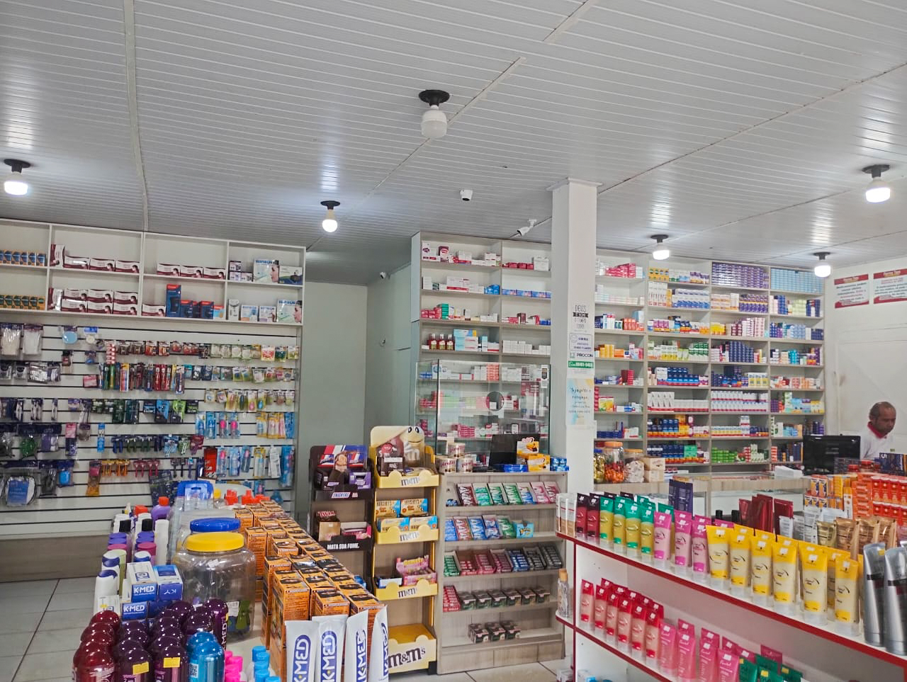 Interior da Farma Tem com prateleiras de medicamentos e produtos de perfumaria